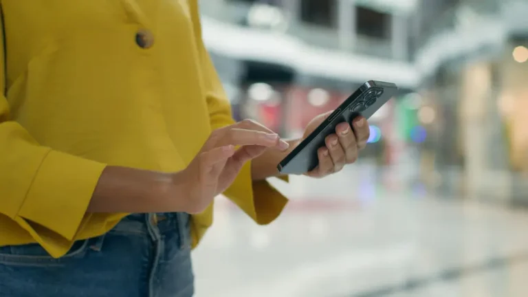 Close-up of an unrecognizable woman holding a smartphone – mobile phone technology, internet ordering.