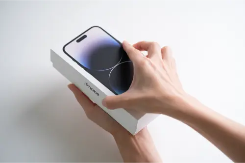 iPhone 14 Pro Max décoche sur fond blanc isolé. Ouverture la boîte pour révéler le téléphone